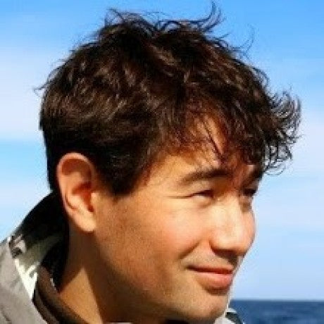 VERY HANDSOME "Asian MAN" with wavy hair against a blue sky and ocean background